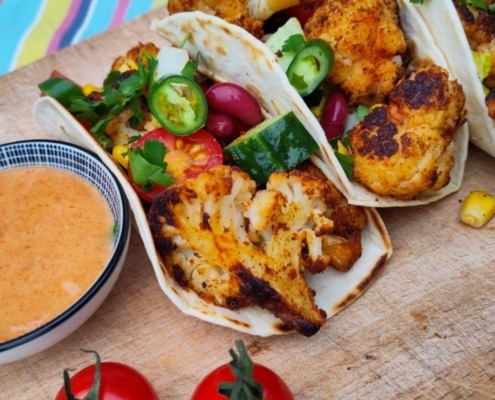 Vegetarische bloemkool recepten – taco's met TexMex geroosterde bloemkool Krokante TexMex gekruide bloemkool in een zachte tortilla, geserveerd met tahinisaus, cherrytomaten en komkommer